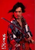 唐橋充 /上半身・衣装青グレー白黒・両手刀・体右向き・キャラクターショット・背景赤/舞台「火男の火」不消者(けされず)15周年記念公演 第二弾・第19回公演ブロマイド