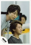 嵐/櫻井翔・大野智/右向き・櫻井前かがみ・奥に人/公式生写真