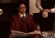 鯨井康介/横型・上半身・衣装茶色・白・座り・両手新聞紙/舞台「怜々蒐集譚 Reirei Syusyu Tan」ブロマイドB